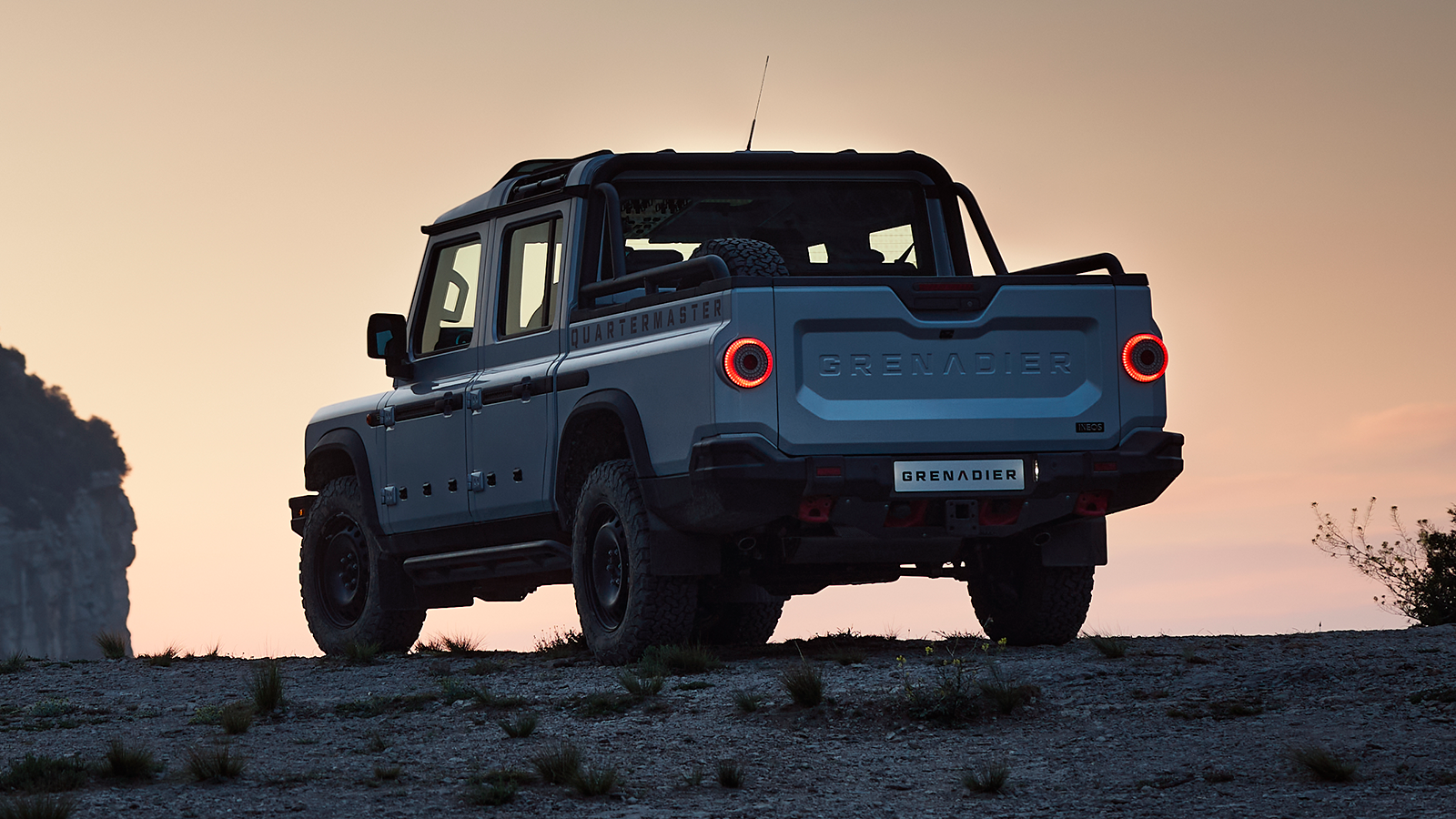 Ineos Grenadier Quartermaster off road pickup truck rear angle sunset