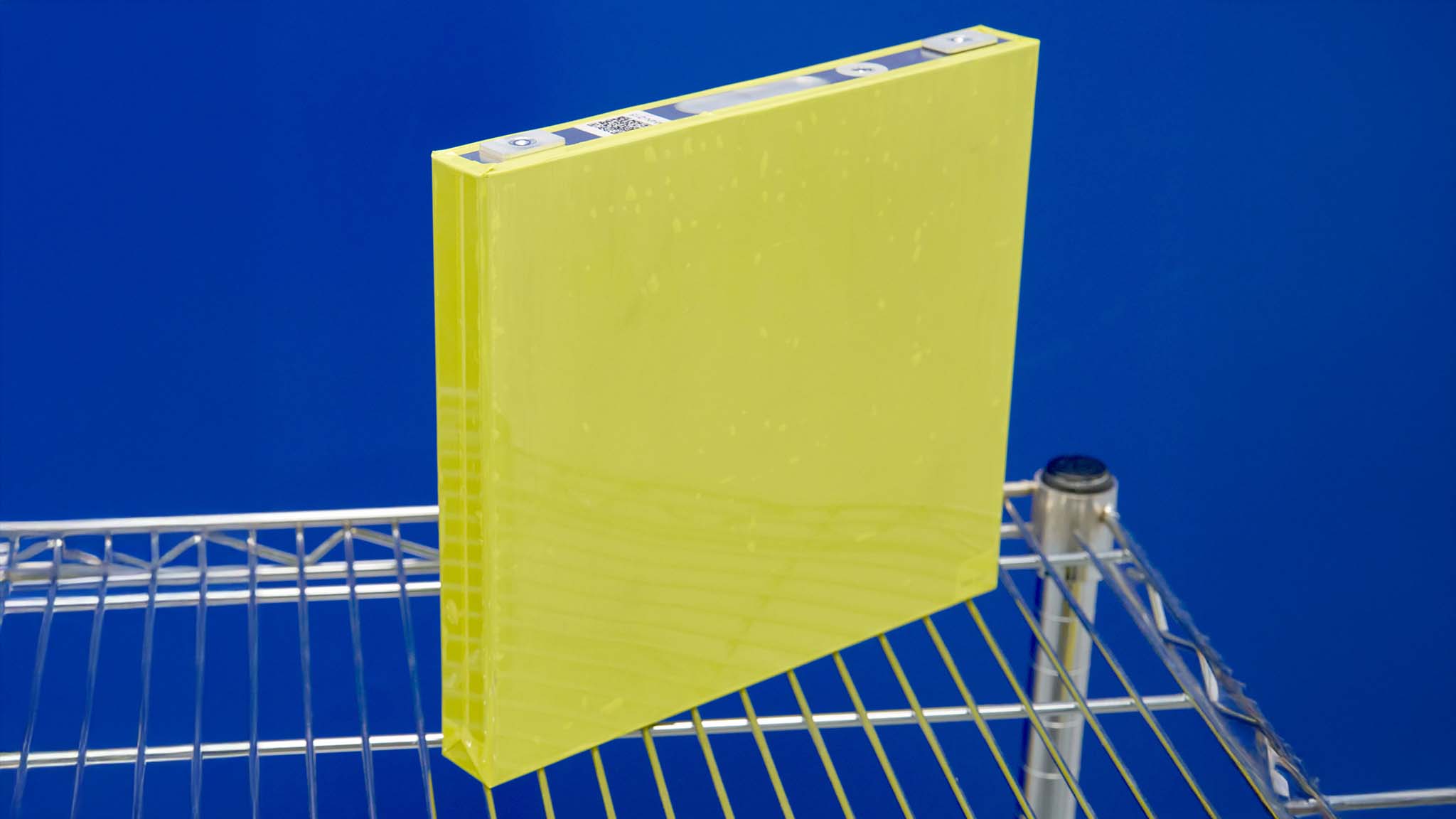 A General Motors LMR prismatic battery cell for use in EV trucks and SUVs on a wire shelving unit..