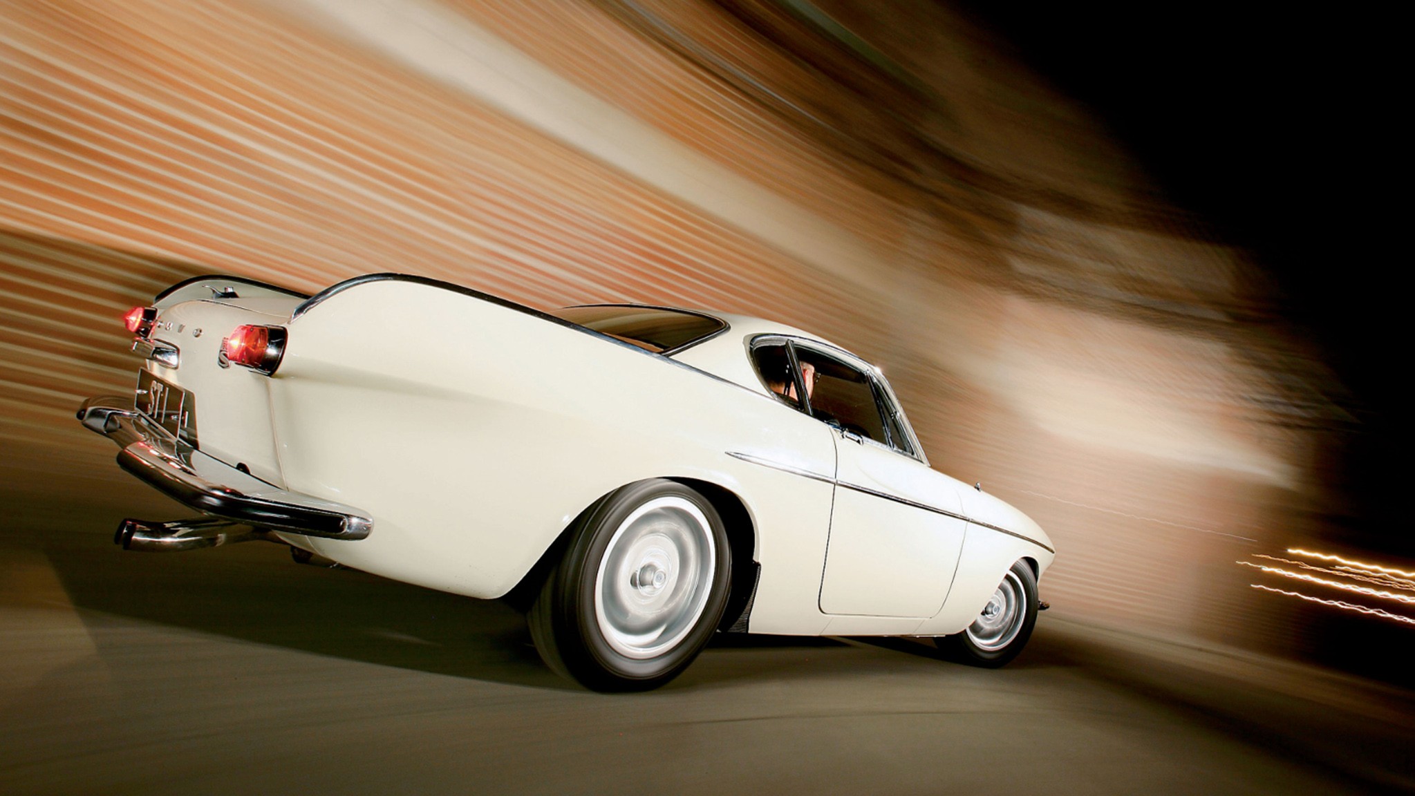 002 roger moore volvo p1800 saint rear three quarter driving refurb